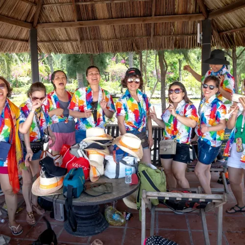 group of women in matching shirts in a hut like shelter
