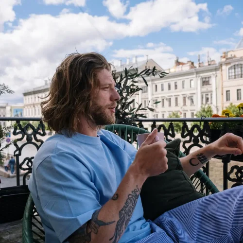 us-guydrinkingcoffeeonabalcony